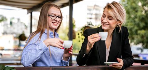 Dve osoby rozprávajúce sa pri káve, jedna mladšia