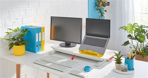 usporiadaný pracovný stôl s počítačom a rastlinou