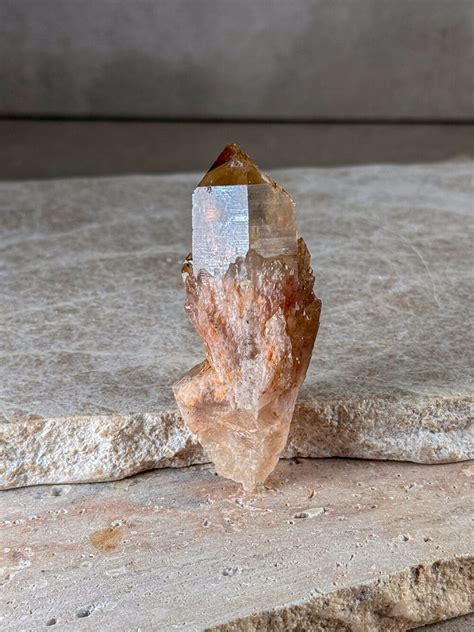 Ruka držiacu kryštál citrínu na pozadí slnka