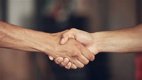 Dve ruky, jedna jemná (Rak) a druhá pevná (Kozorožec), si podávajú.