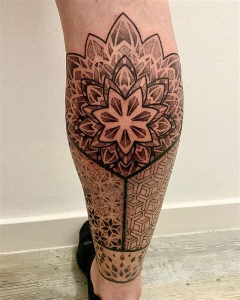 Detailná umelecká mandala vytetovaná na ženskom lýtku s geometrickými prvkami