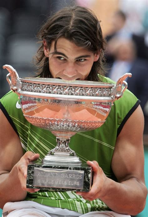 Rafael Nadal biting a trophy