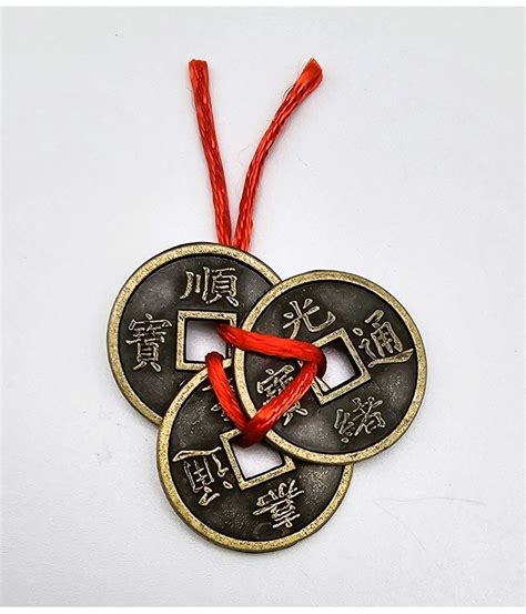 Tri čínske mince zviazané červenou šnúrkou